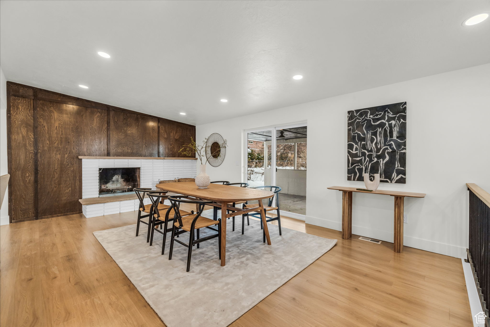 Dining space featuring light hardwood / wood-style flooring and a brick fireplace