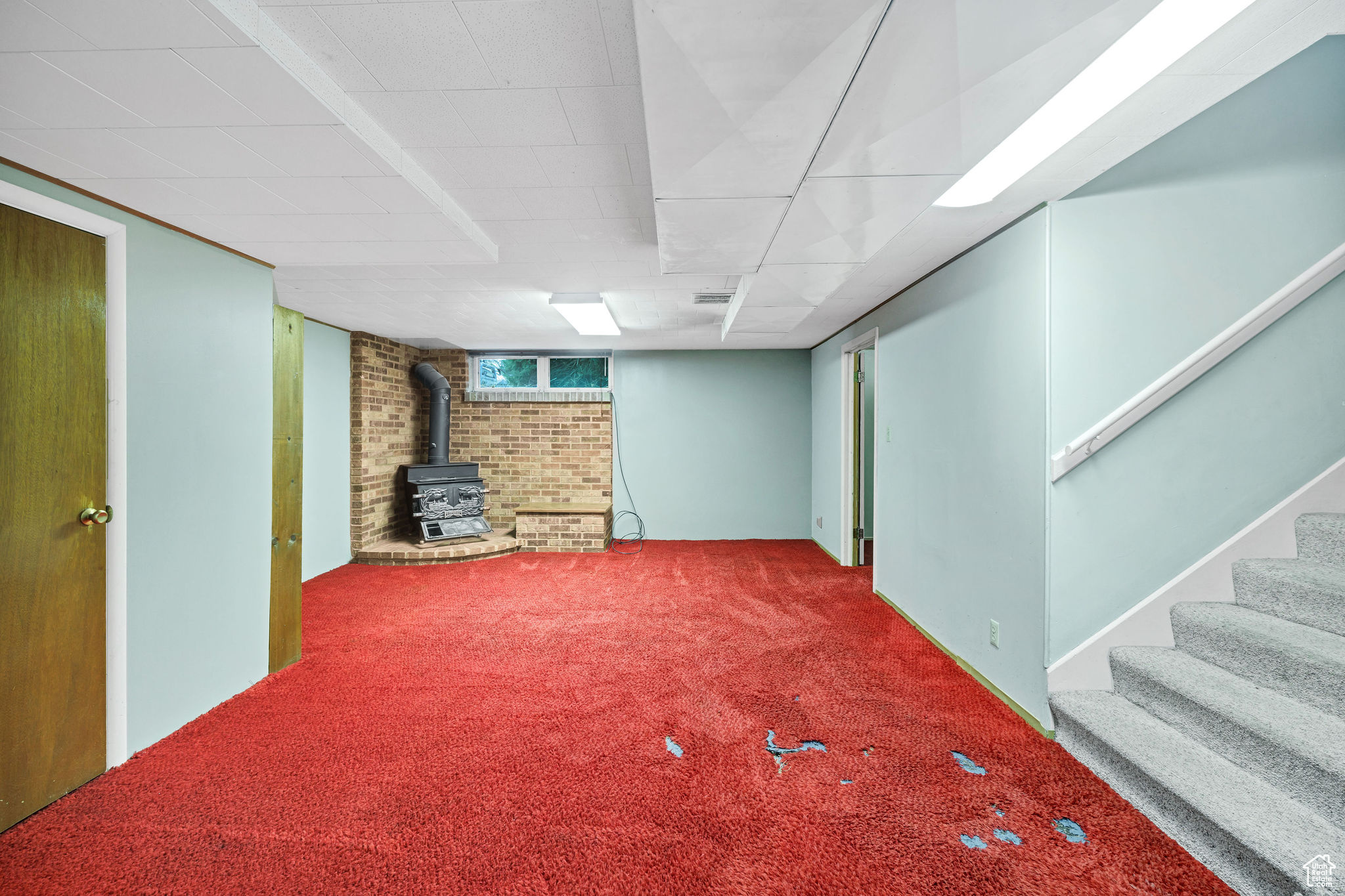 Basement featuring carpet and a wood stove