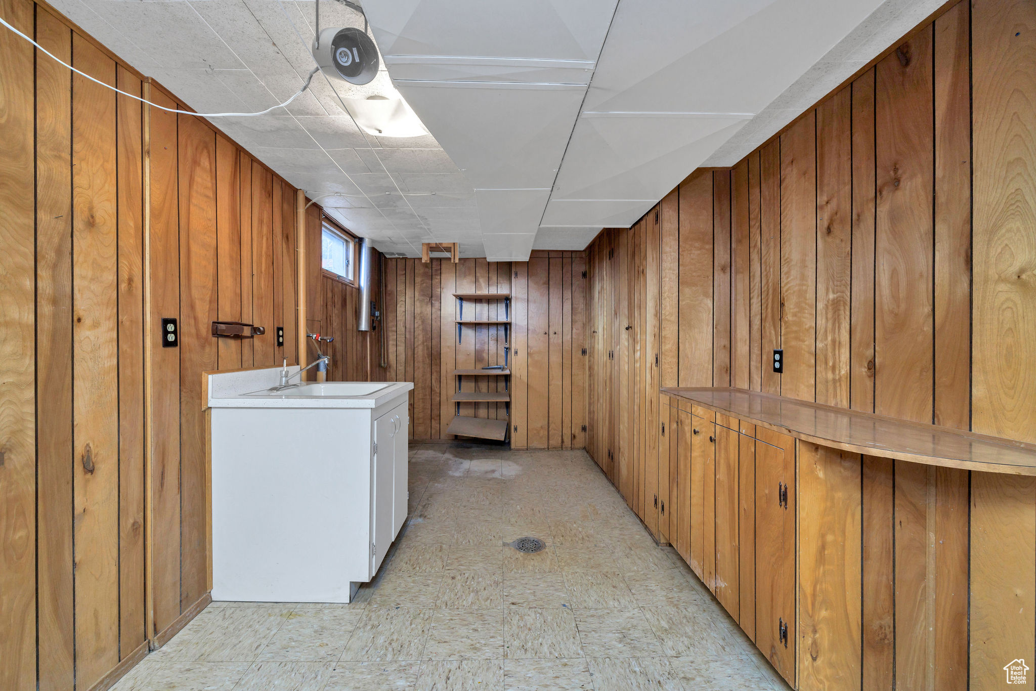 Washroom with wooden walls and sink