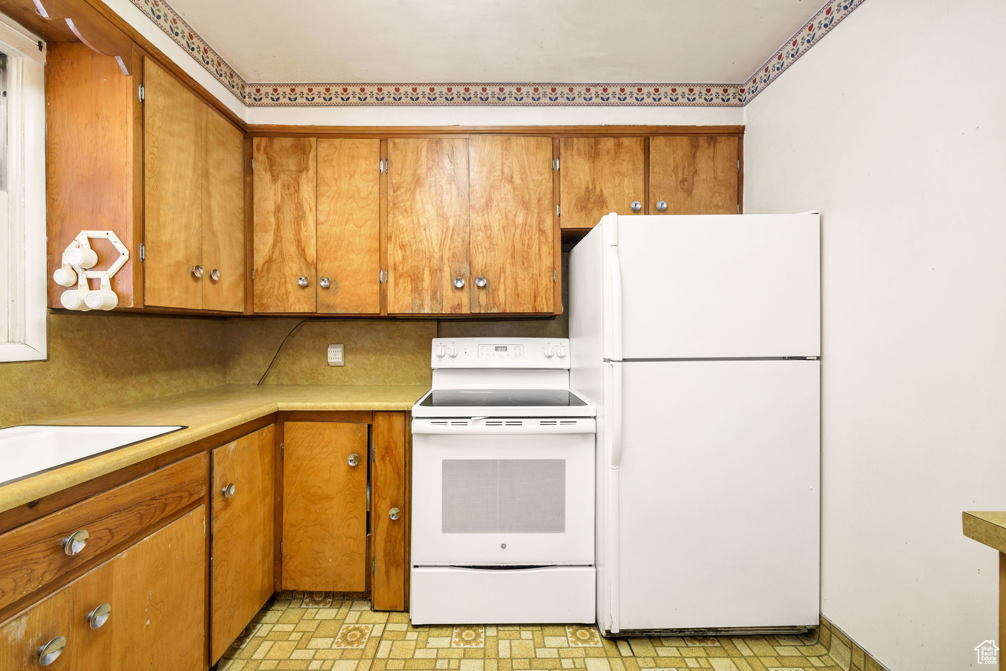 Kitchen with decorative backsplash and white appliances