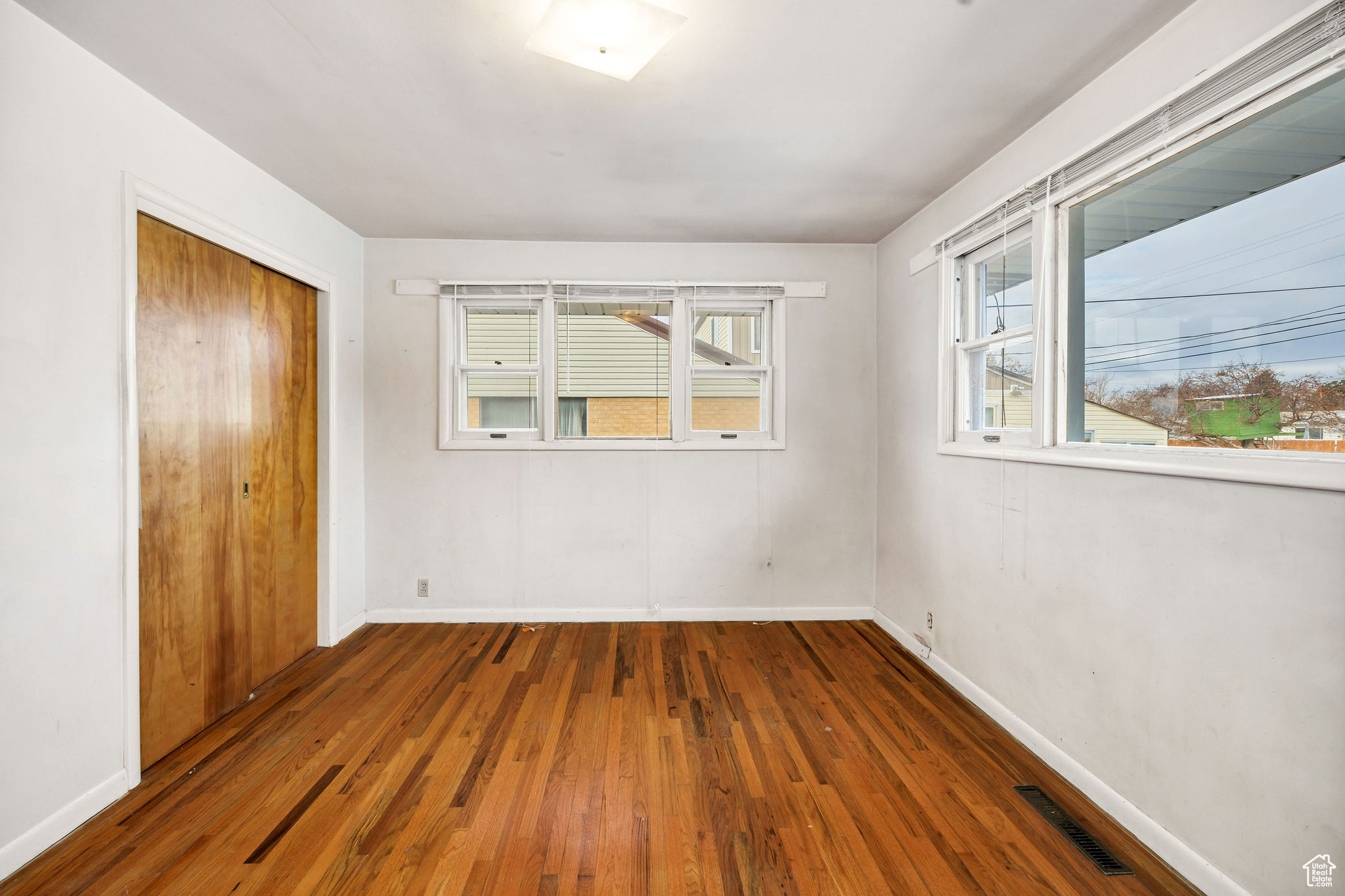 Unfurnished bedroom with dark wood-type flooring and a closet