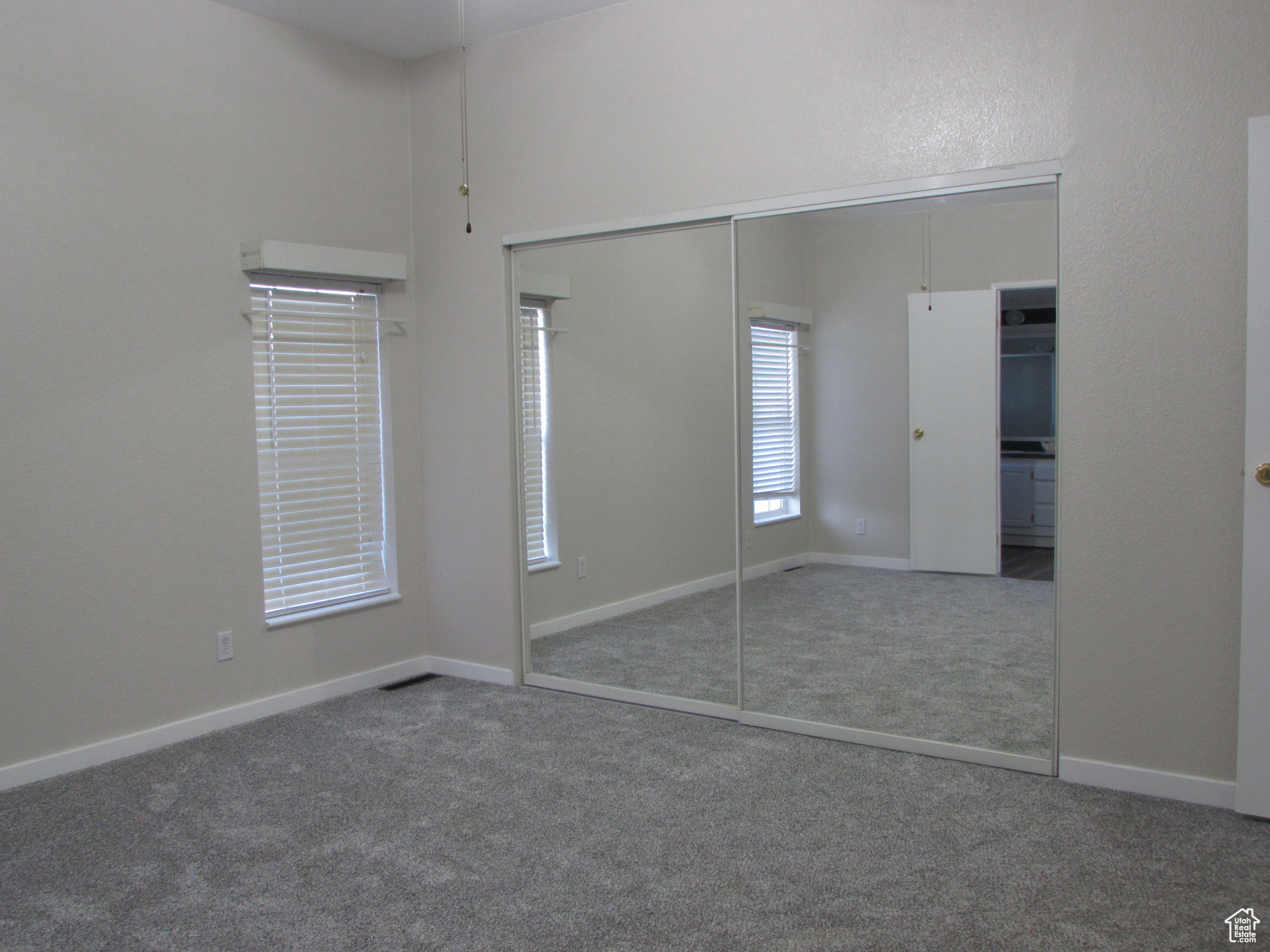 Master bedroom featuring new carpet, new paint, and mirrored closet doors