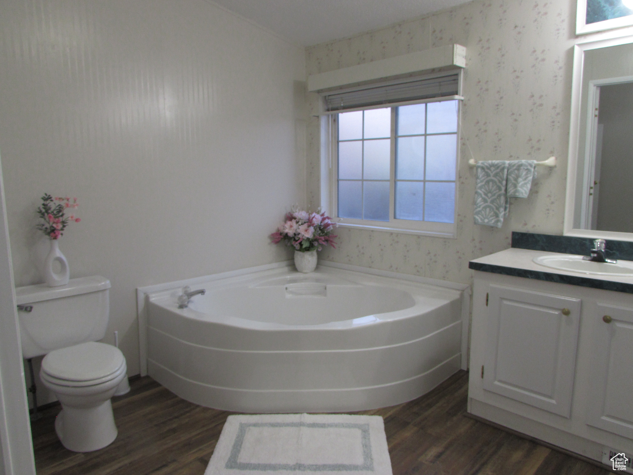 Master Bathroom featuring hardwood / wood-style floors, vanity, a tub to relax in, and toilet