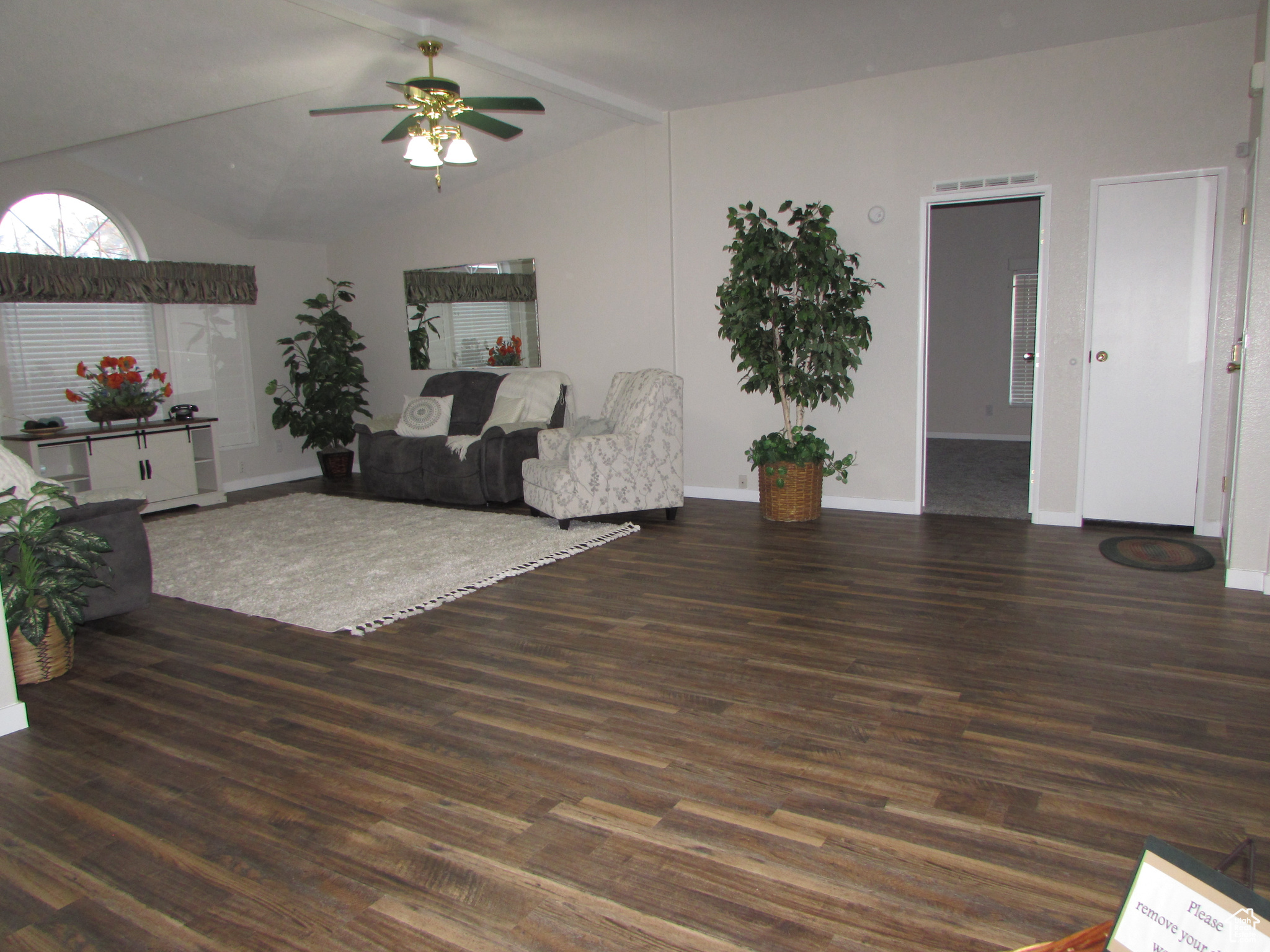 Living room featuring ceiling fan, lofted ceiling, and dark hardwood / wood-style floors