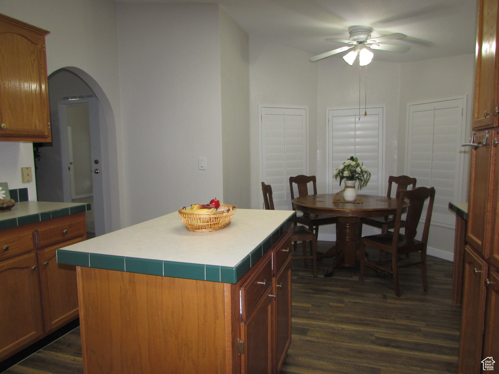 Kitchen & Dining area featuring dark hardwood / wood-style flooring, ceiling fan, and a center island