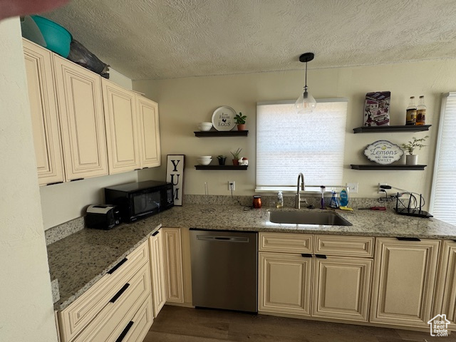 Kitchen with stainless steel dishwasher, dark stone counters, a textured ceiling, sink, and decorative light fixtures