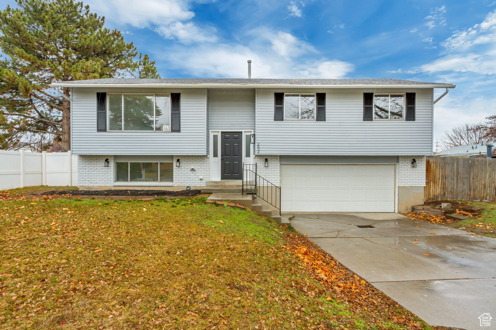 Split foyer home featuring a front yard and a garage