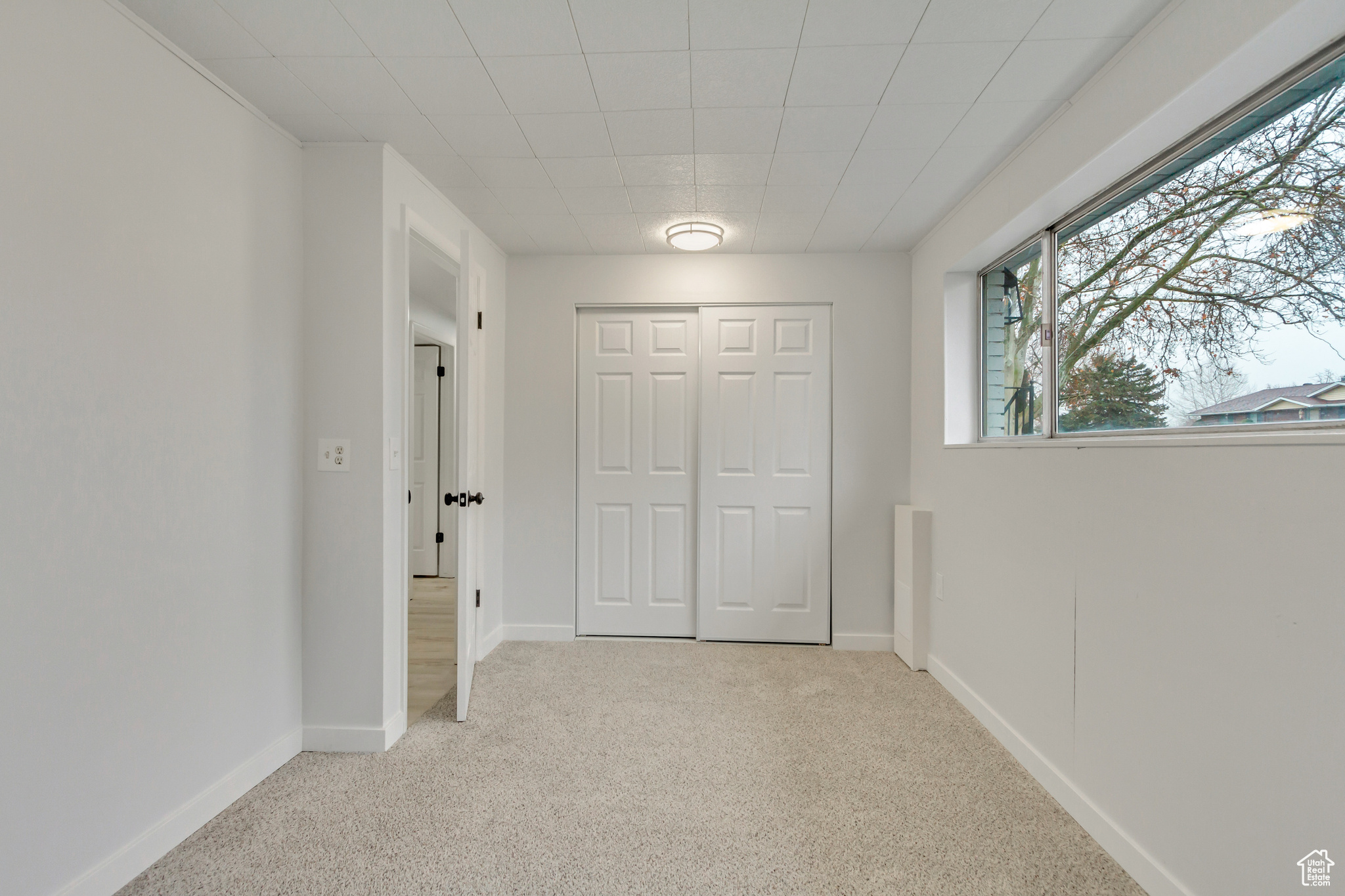 Corridor featuring light carpet