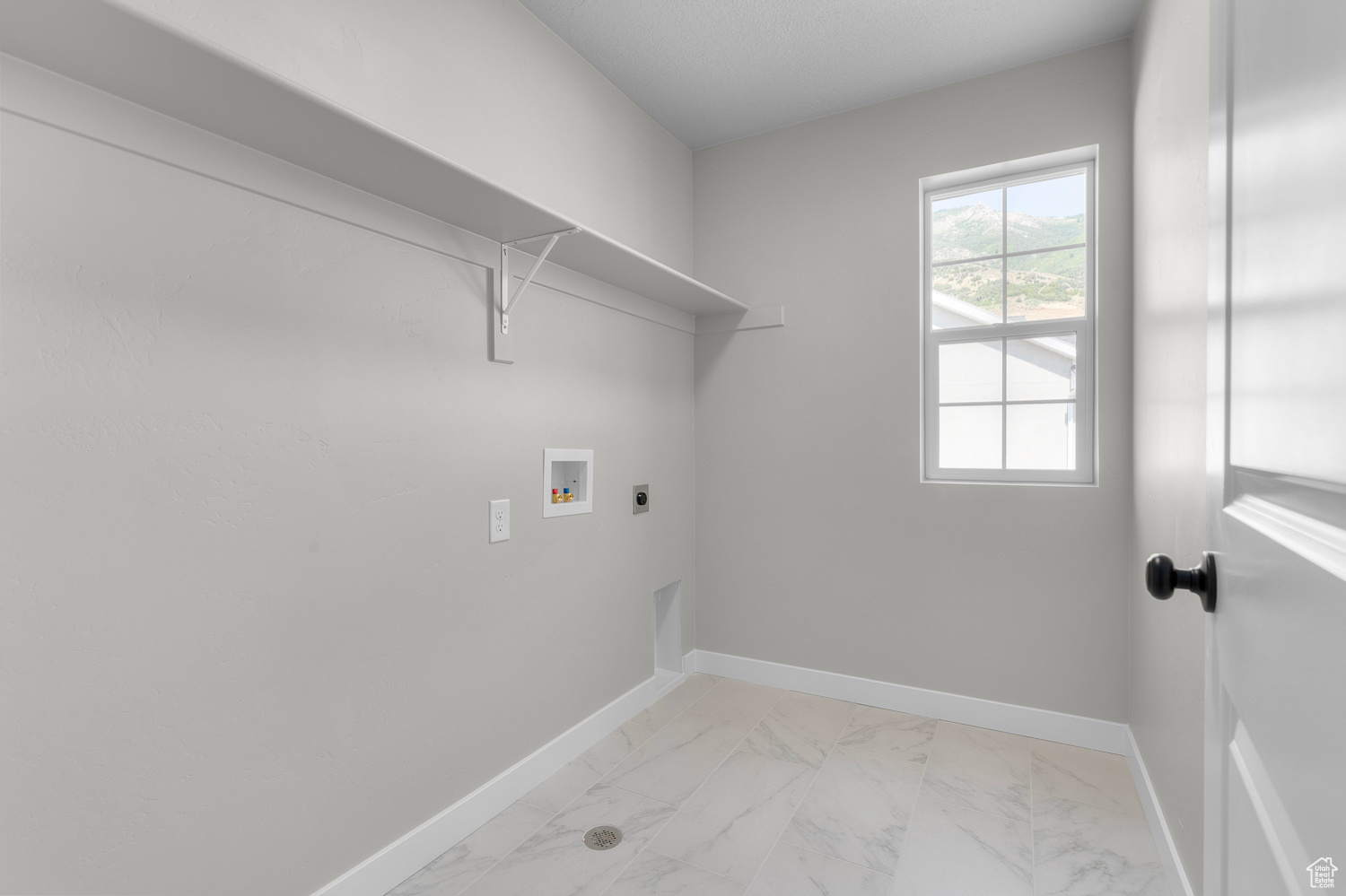 Clothes washing area featuring washer hookup and hookup for an electric dryer