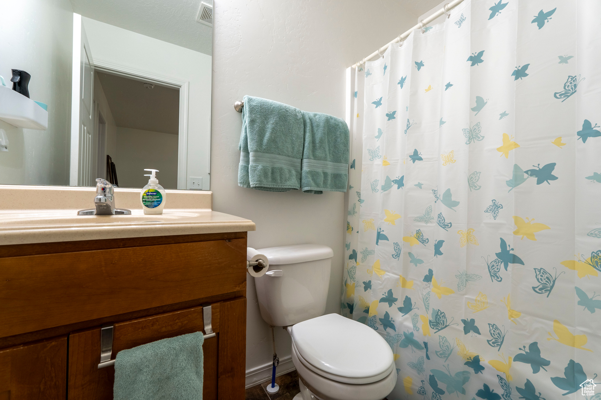 Bathroom featuring walk in shower, vanity, and toilet