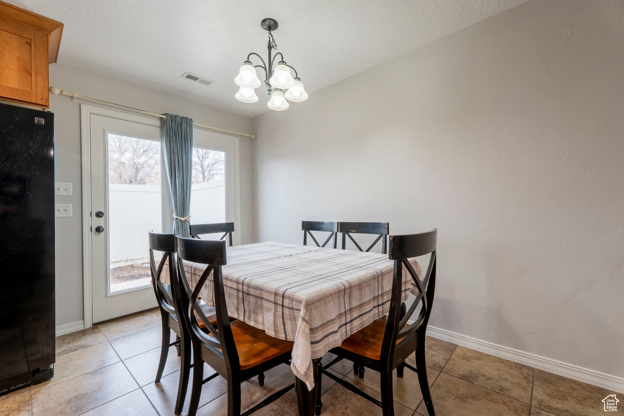 Dining space with a notable chandelier, plenty of natural light, and light tile patterned floors