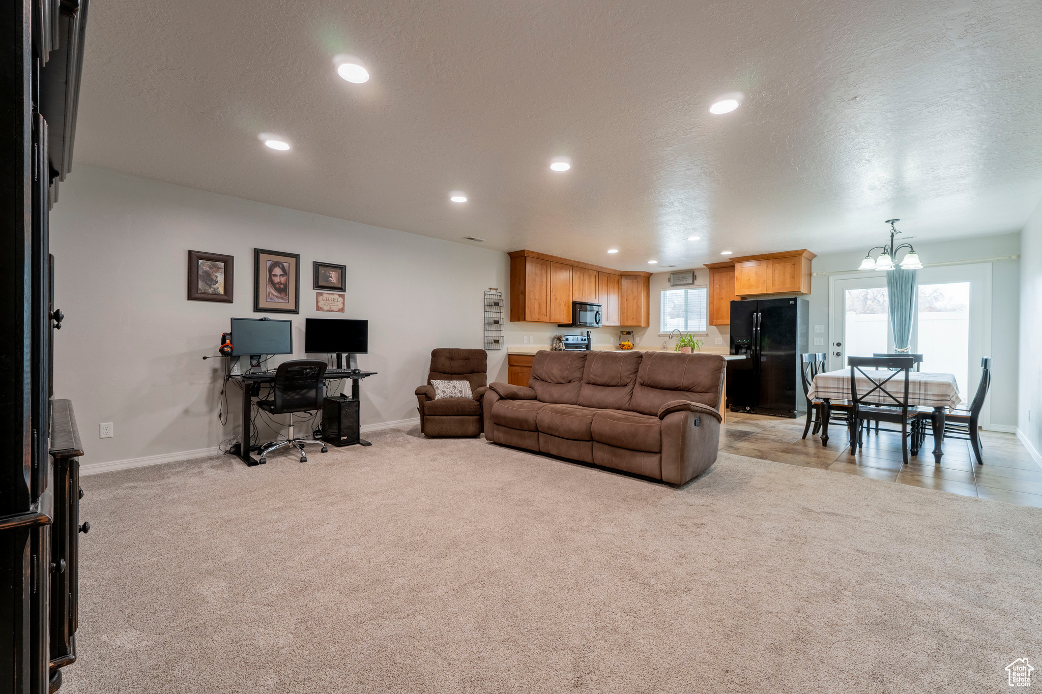 Carpeted living room with a chandelier and a textured ceiling