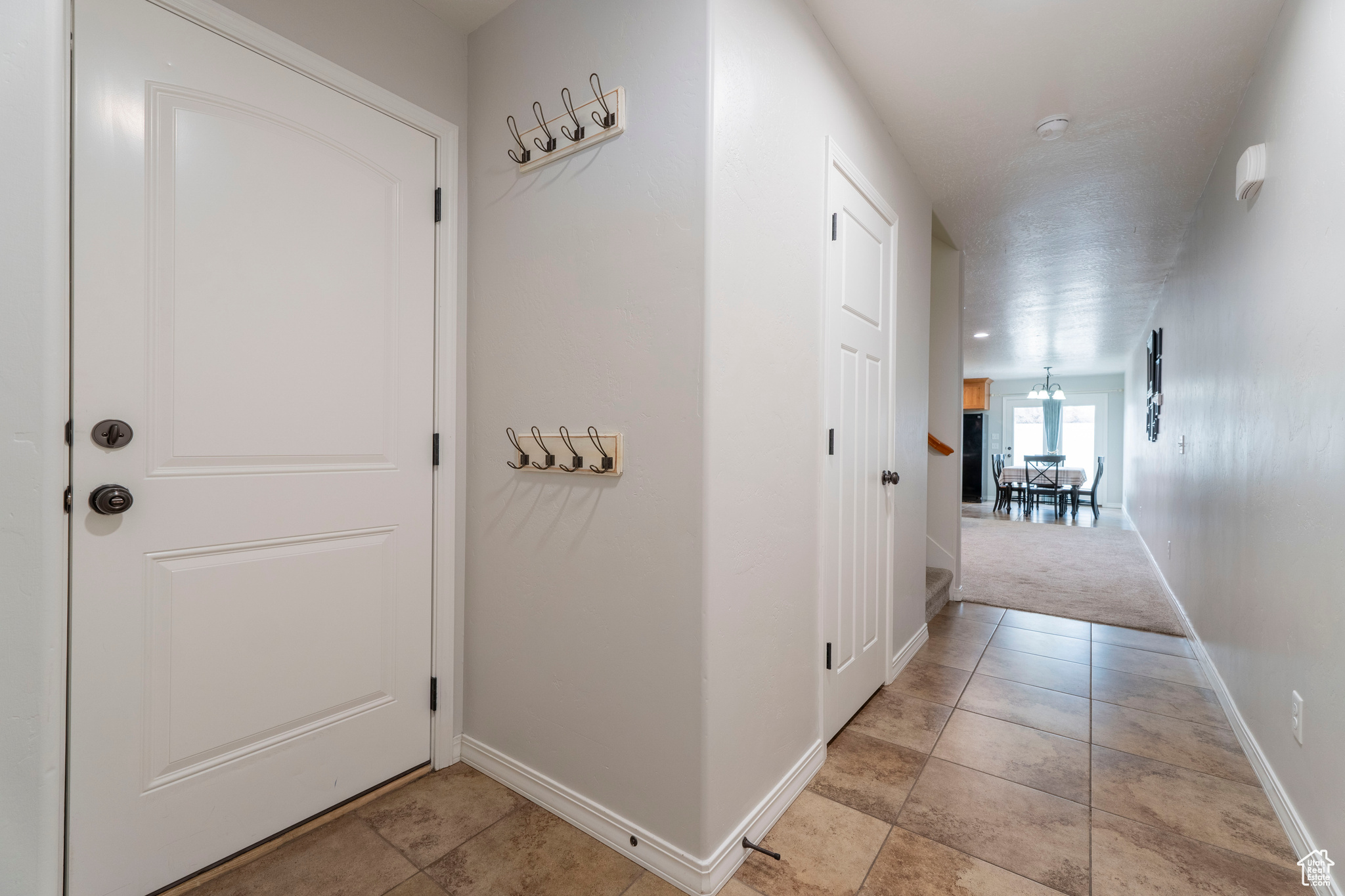 Hallway featuring light colored carpet