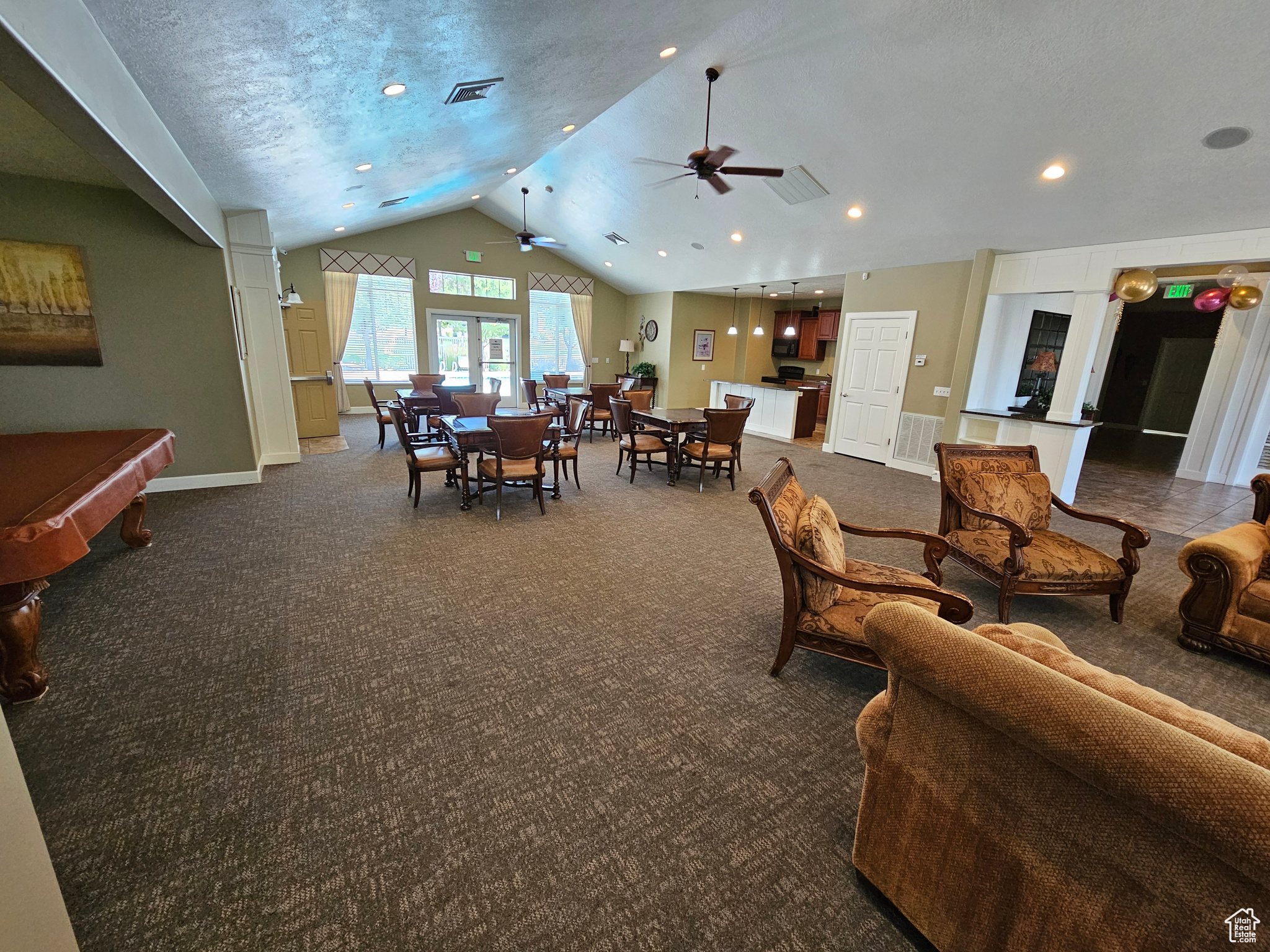 Living room with ceiling fan, lofted ceiling, a textured ceiling, dark carpet, and pool table