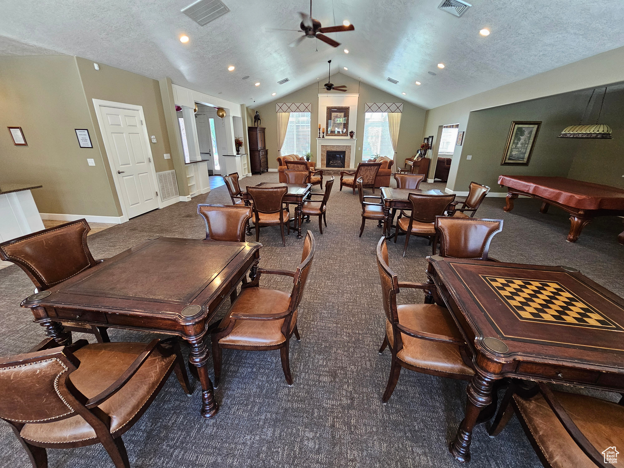 Carpeted dining space featuring a textured ceiling, ceiling fan, lofted ceiling, and pool table