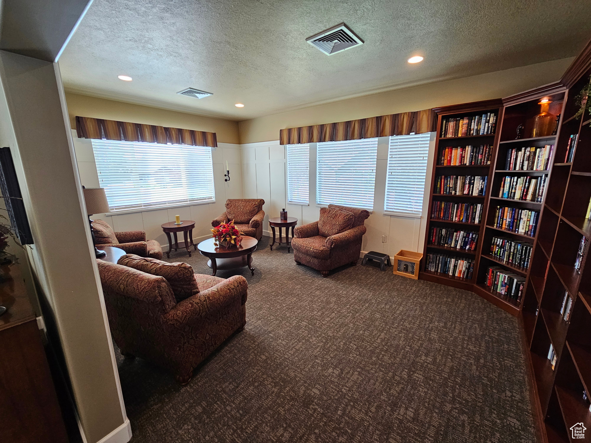 Living room featuring carpet and a textured ceiling