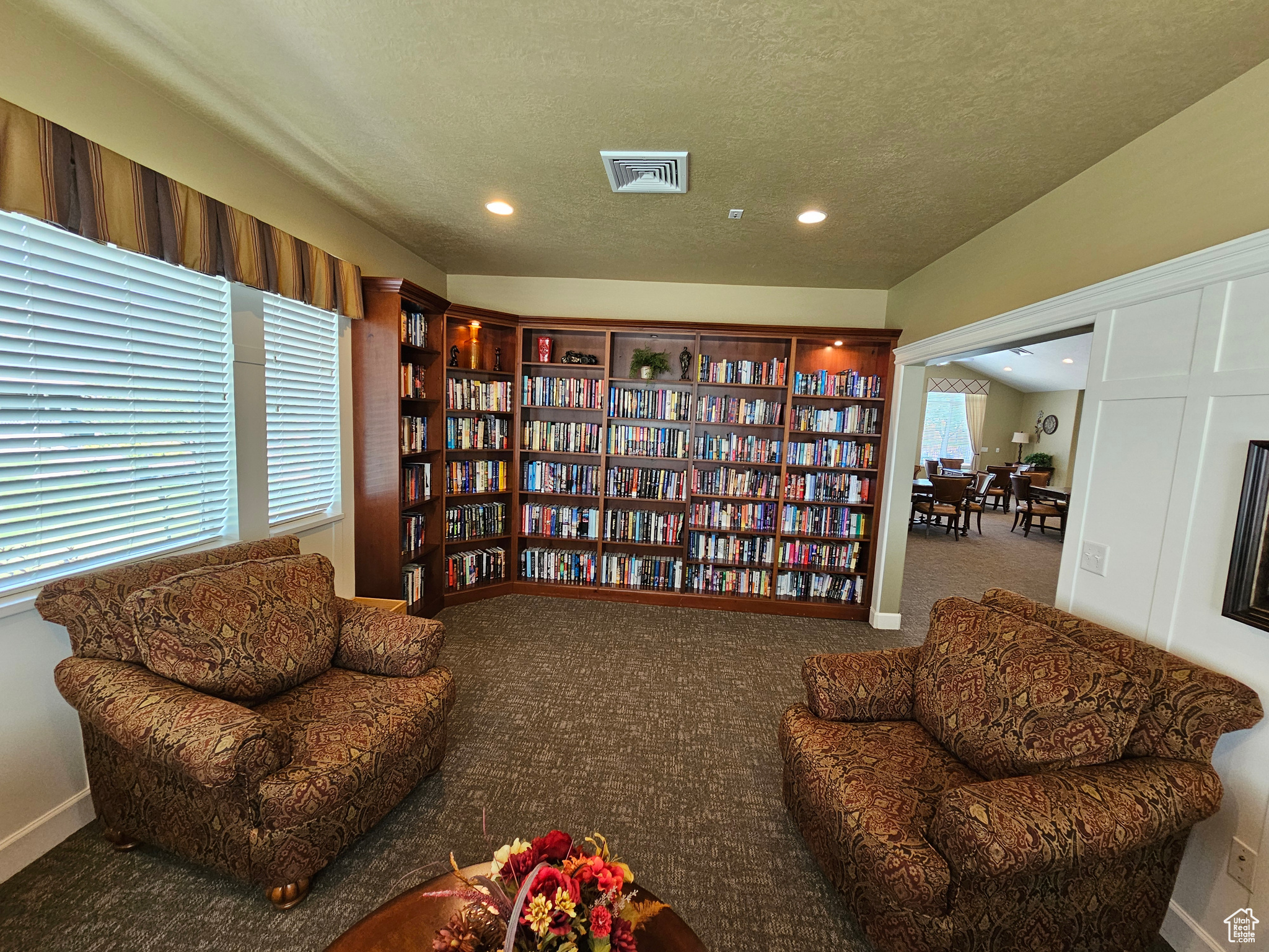 Sitting room with carpet flooring, a textured ceiling, and a wealth of natural light