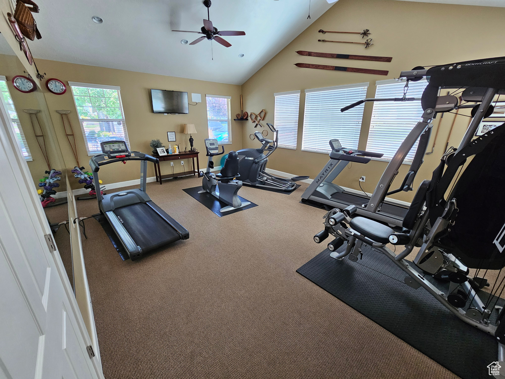 Exercise room with ceiling fan, carpet floors, and lofted ceiling