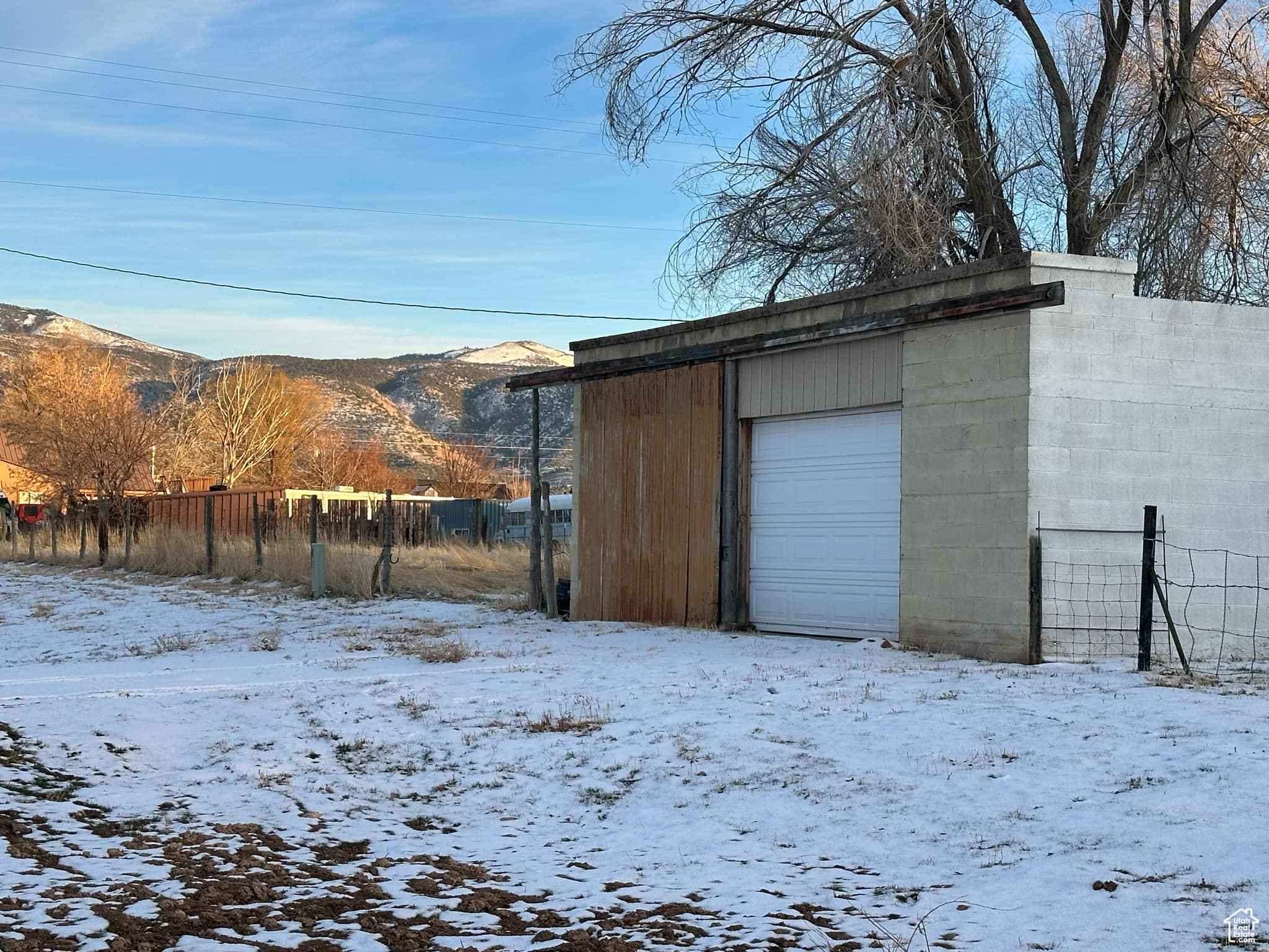 Snow covered garage featuring a mountain view