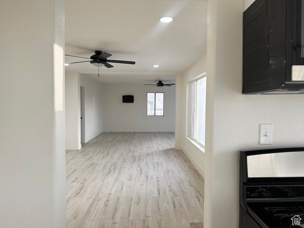 Interior space featuring ceiling fan, light hardwood / wood-style floors, a textured ceiling, and range