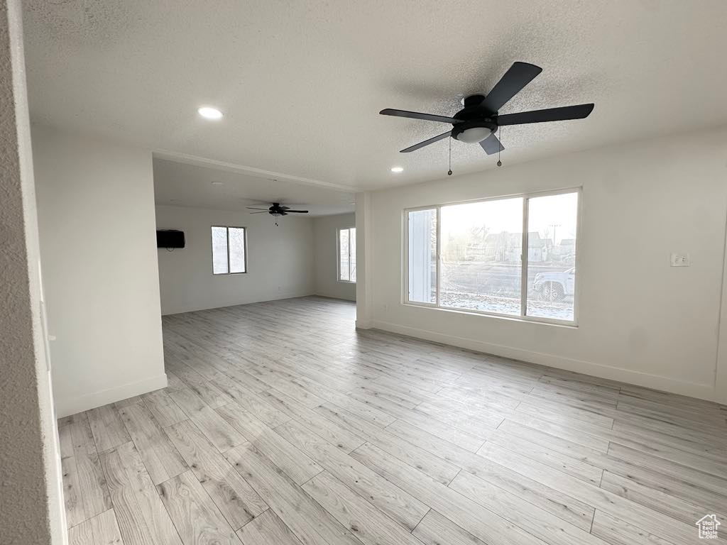 Spare room with a textured ceiling, light hardwood / wood-style floors, and ceiling fan