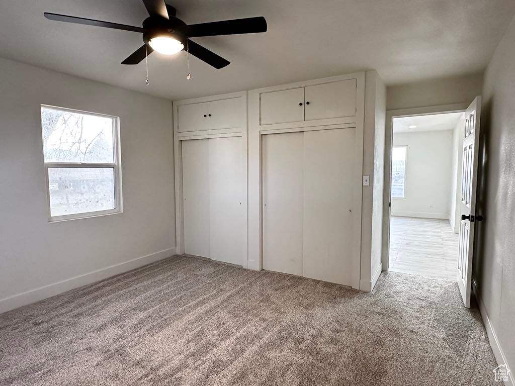 Unfurnished bedroom with light carpet and ceiling fan