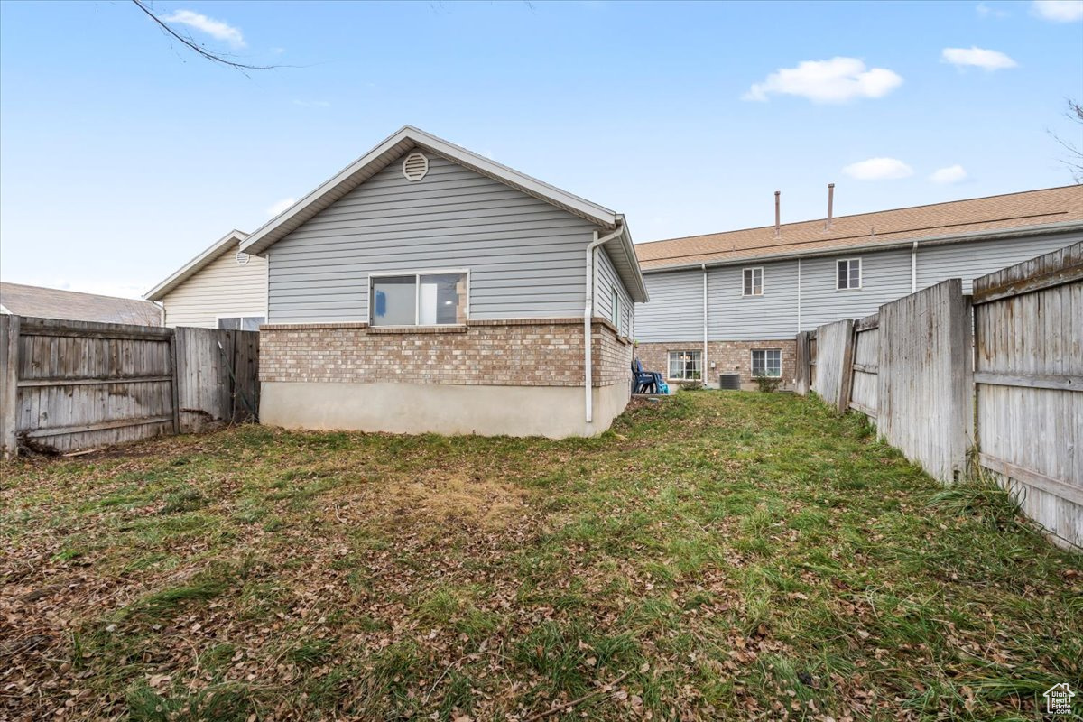 Rear view of house featuring a fenced lawn