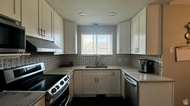 Kitchen featuring sink, white cabinets, and appliances with stainless steel finishes