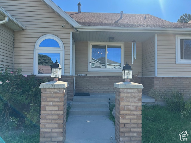 View of exterior entry featuring covered porch