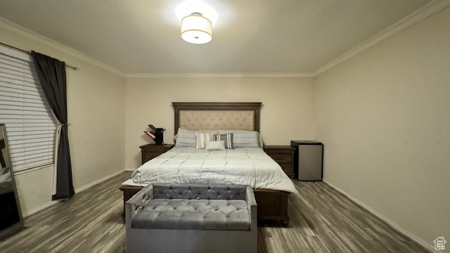 Bedroom with dark hardwood / wood-style floors and ornamental molding