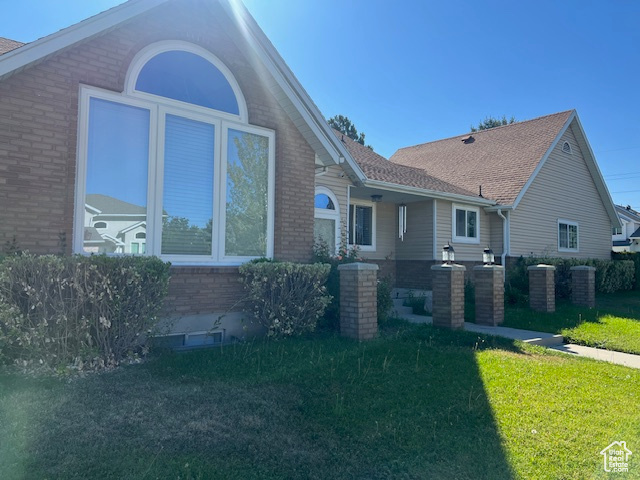 View of front of property with cooling unit and a front lawn