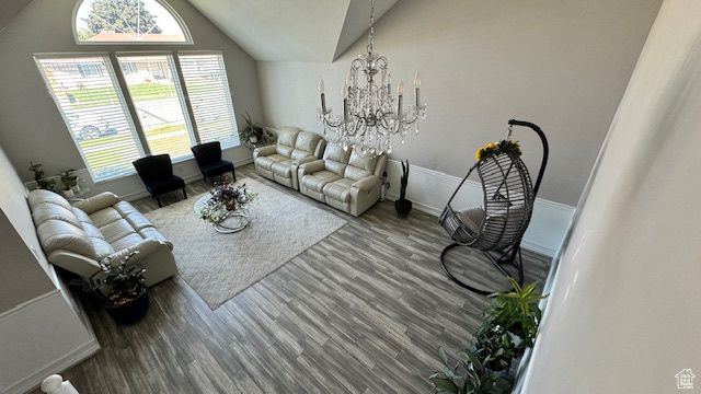 Living room featuring hardwood / wood-style floors, a chandelier, and vaulted ceiling