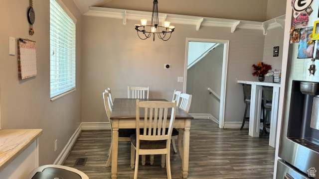 Dining area featuring a notable chandelier and dark hardwood / wood-style flooring