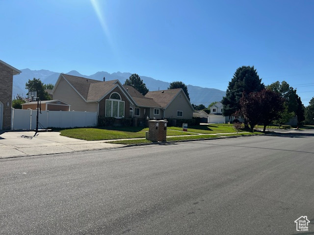 Single story home featuring a mountain view and a front yard