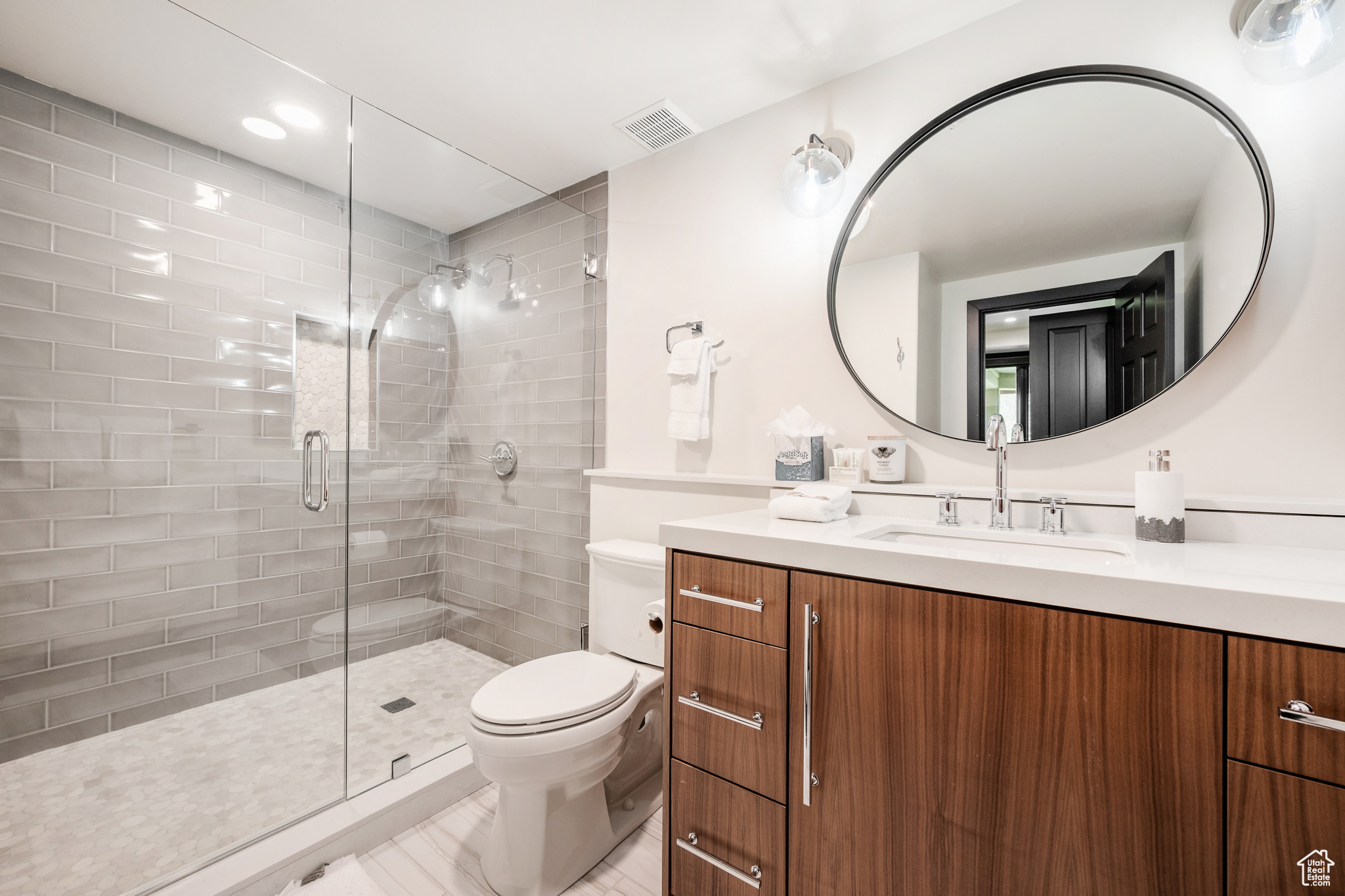 Bathroom with vanity, toilet, and an enclosed shower