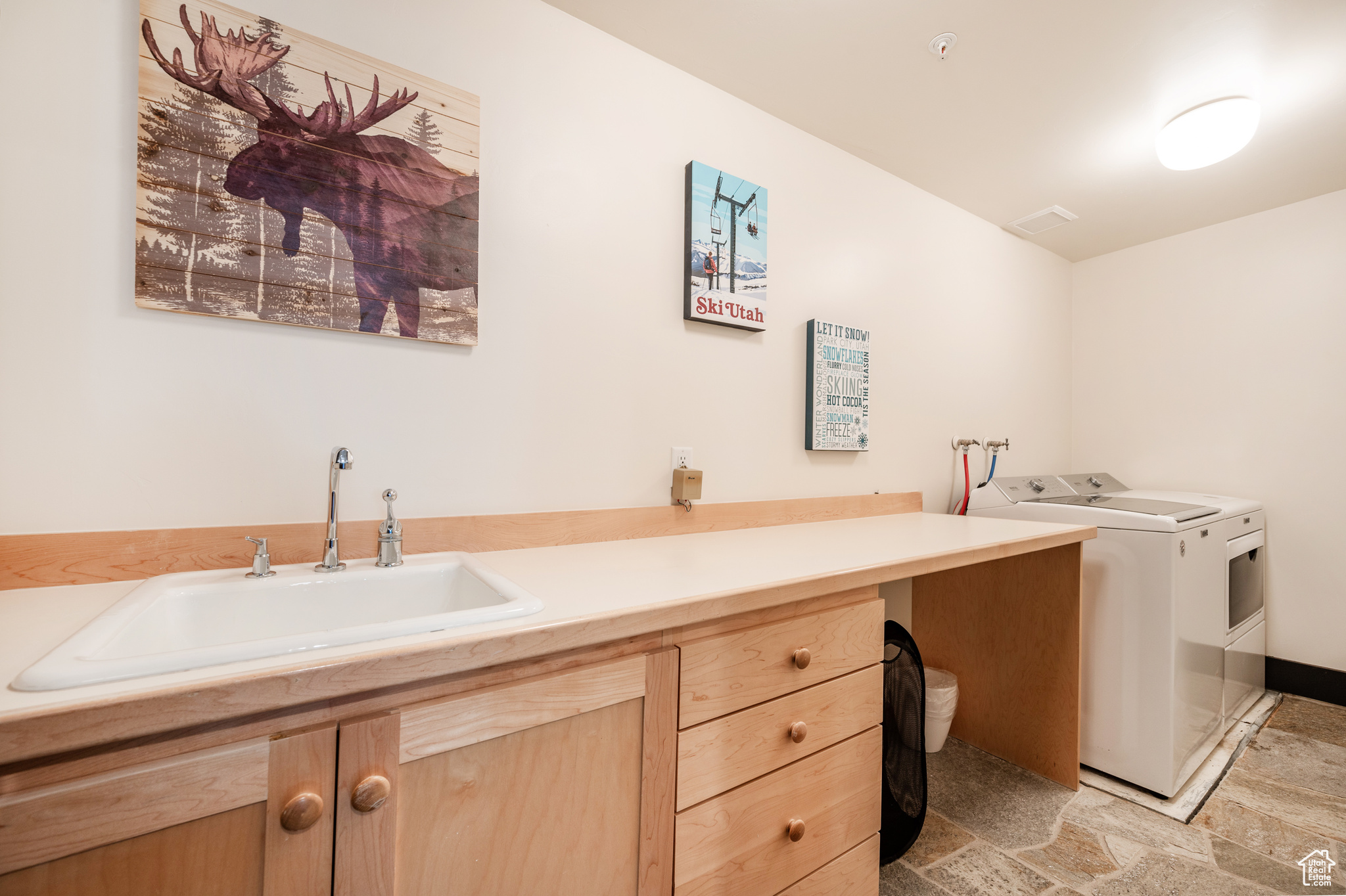 Washroom featuring cabinets, separate washer and dryer, and sink