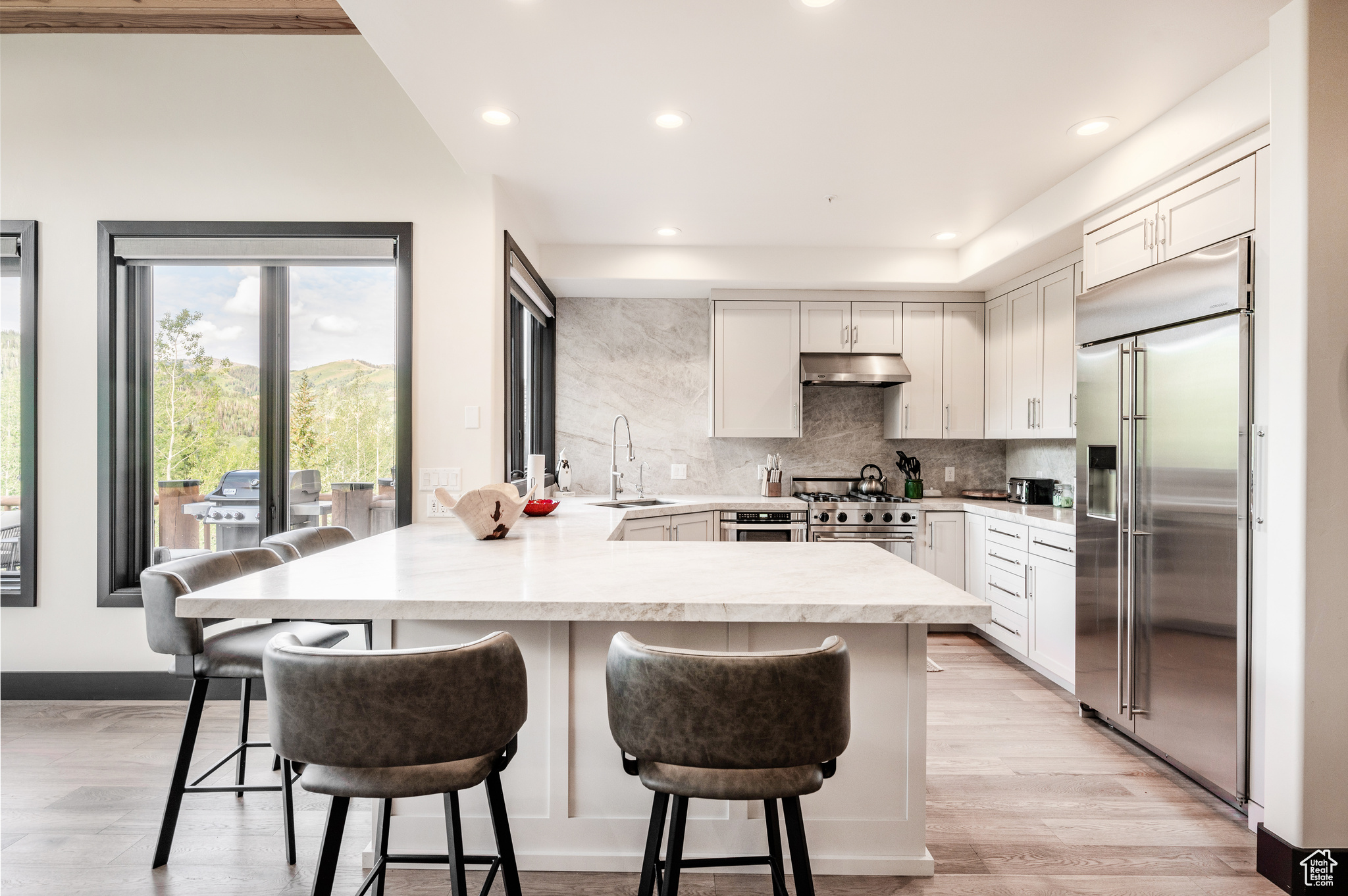 Kitchen with kitchen peninsula, high quality appliances, a breakfast bar, and sink