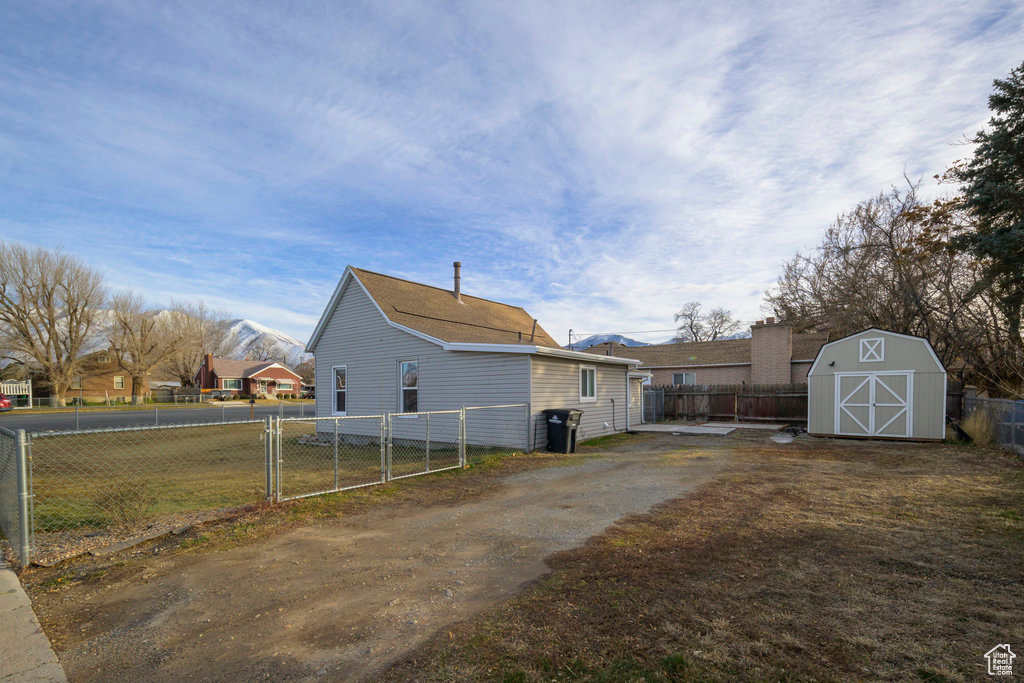 View of side of property with a storage shed and lots of parking