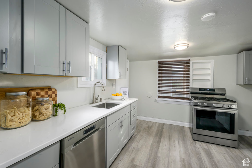 Kitchen featuring sink, light wood-type flooring, and appliances with stainless steel finishes