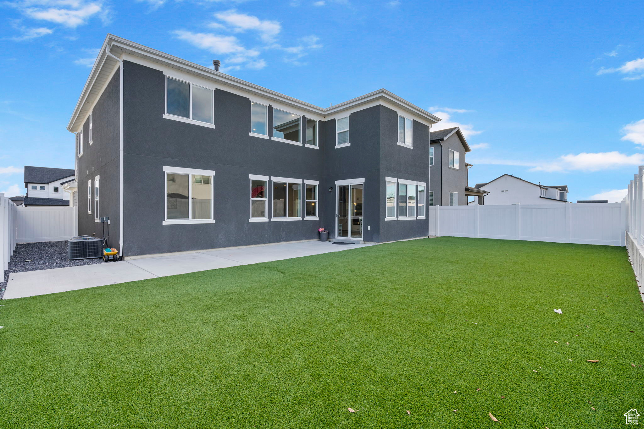 Back of house featuring a patio area, a yard, and central AC