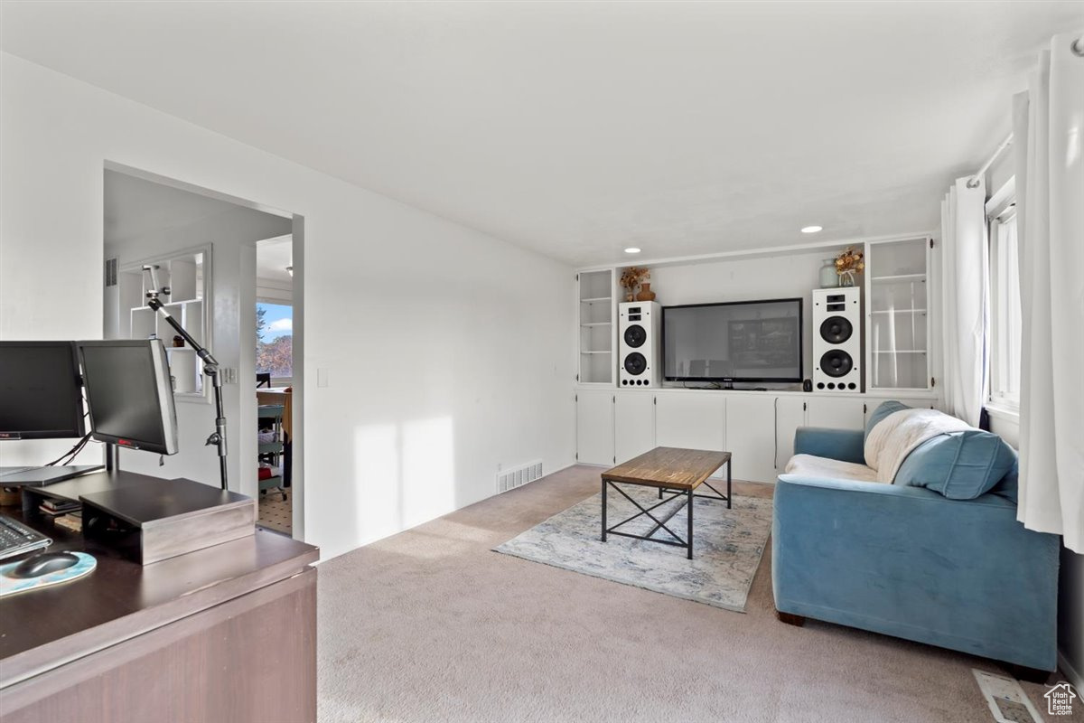 Carpeted living room featuring built in entertainment center