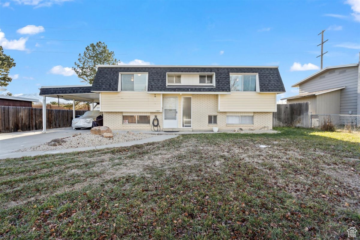 View of front of property featuring a front yard and a carport