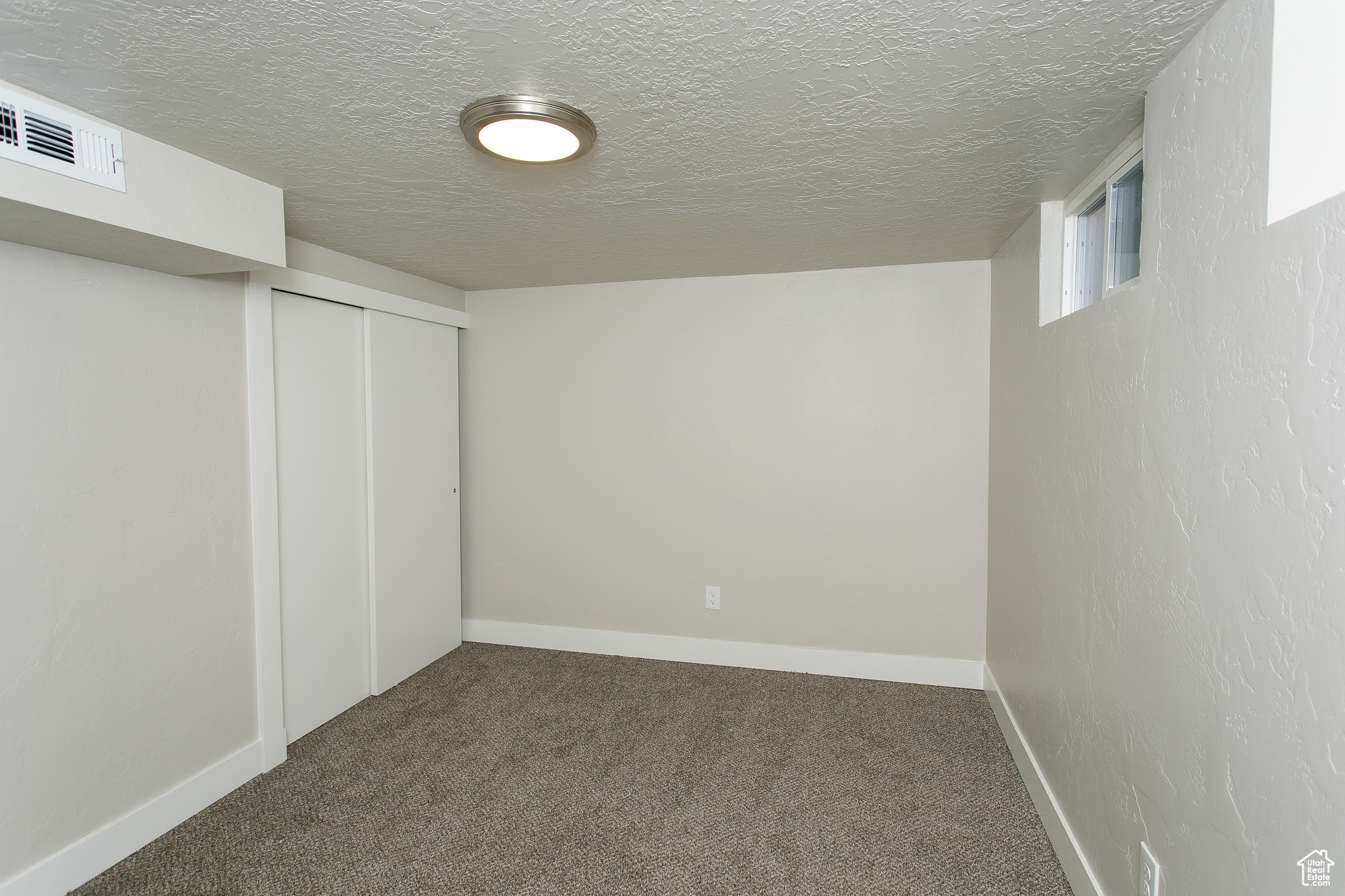 Basement featuring carpet and a textured ceiling