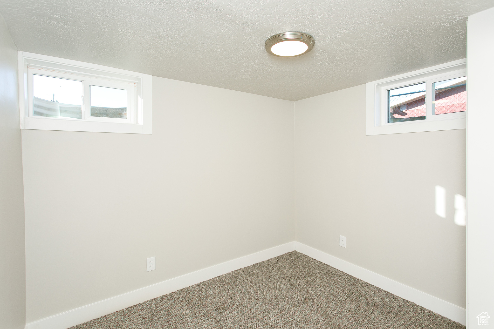 Basement featuring carpet floors and a textured ceiling