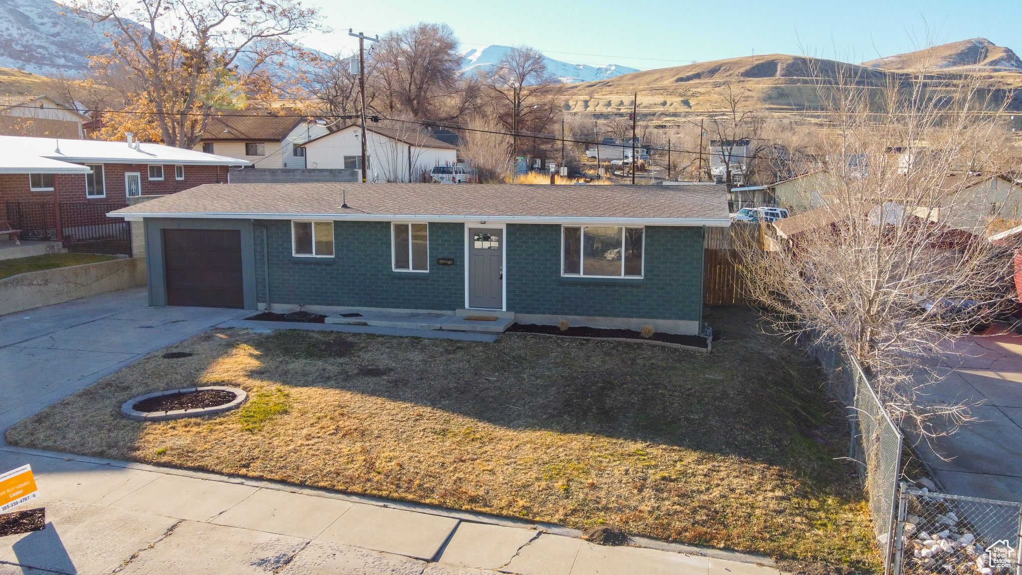 Ranch-style home featuring a mountain view, a front lawn, and a garage