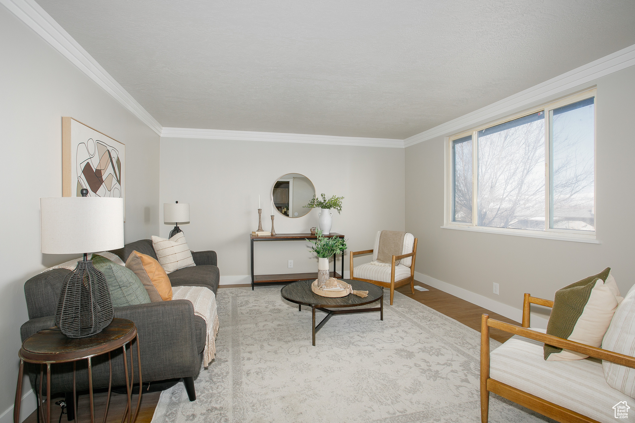 Living room with hardwood / wood-style floors and crown molding