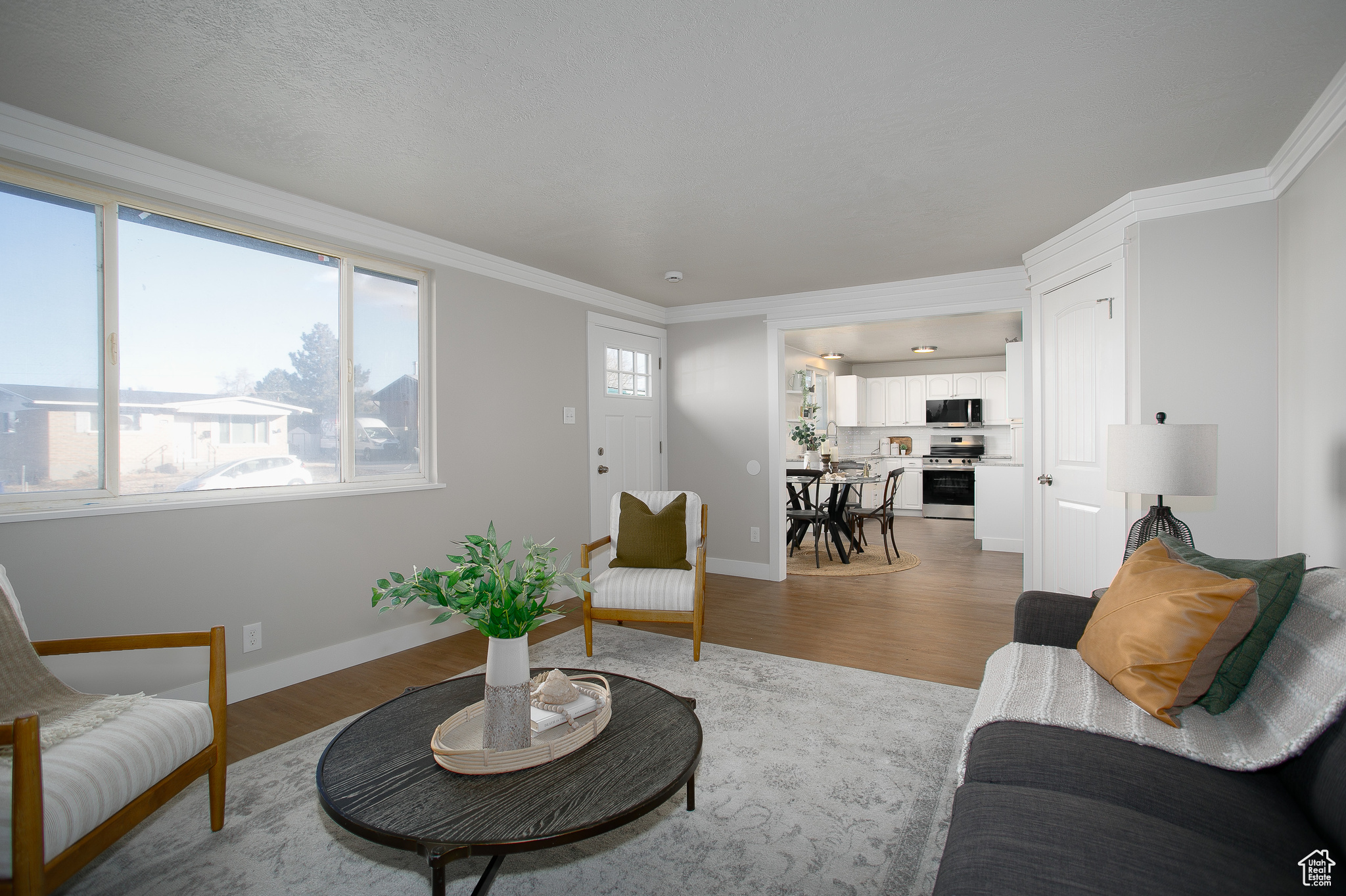 Living room with wood-type flooring and crown molding