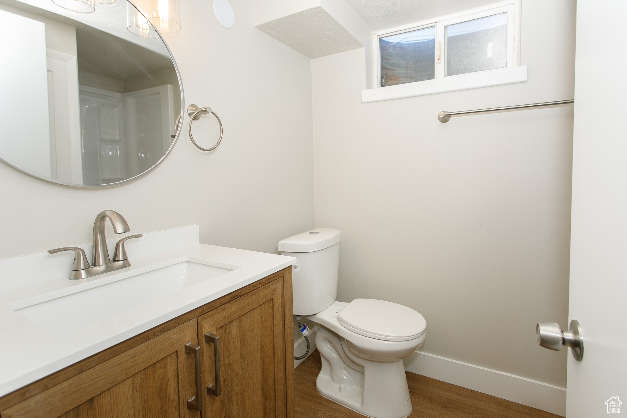 Bathroom with hardwood / wood-style floors, vanity, and toilet