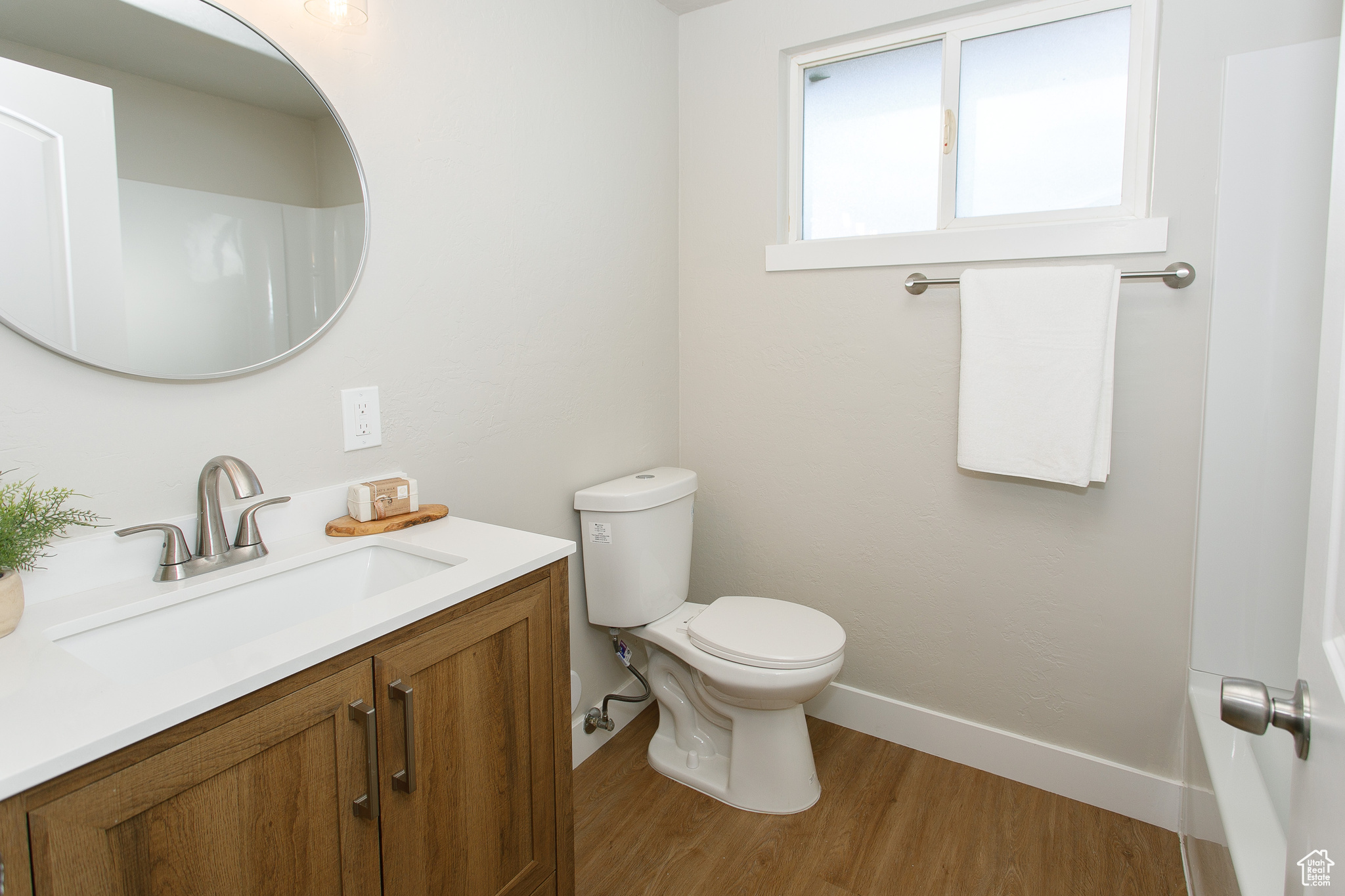 Bathroom featuring hardwood / wood-style floors, vanity, and toilet