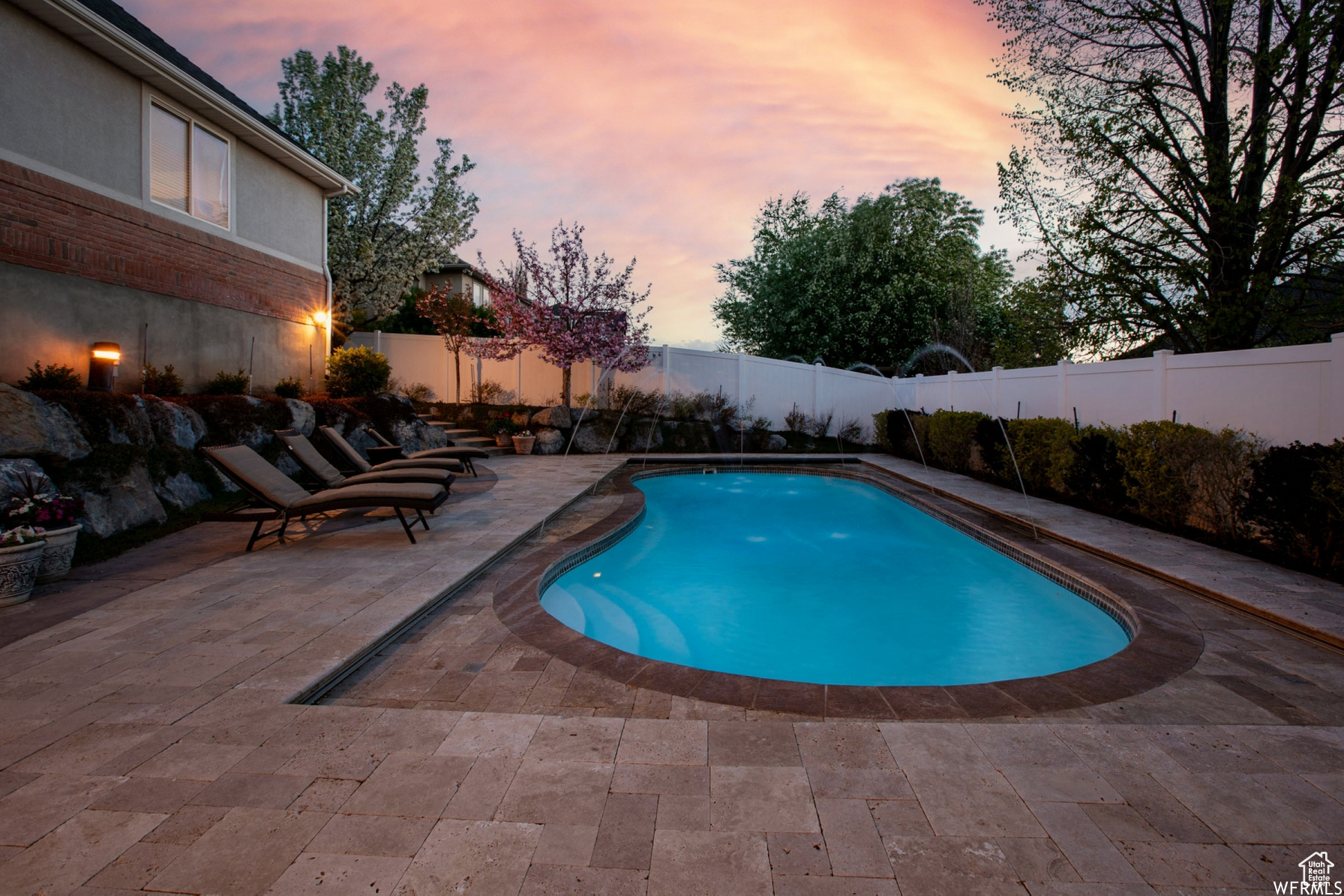 Pool at dusk featuring a sundeck